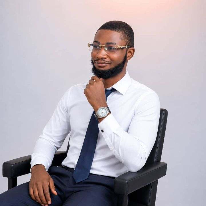 Portrait of RemzyPro, Shopify expert and e-commerce SEO specialist, seated in a white shirt and navy tie